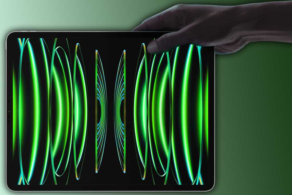 hand holding an iPad Pro with green wallpaper